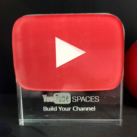 Red glass play button with text that says: 